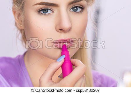 Hot girl putting on lipstick