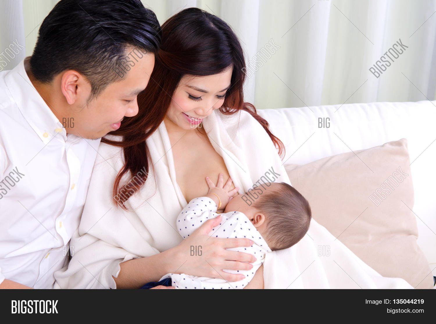Asian woman breast feeding man